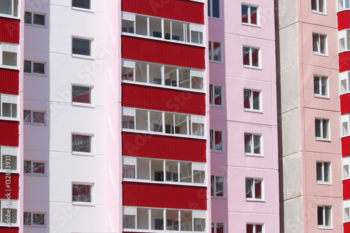 Part of new pink residential building with red balconies and dou