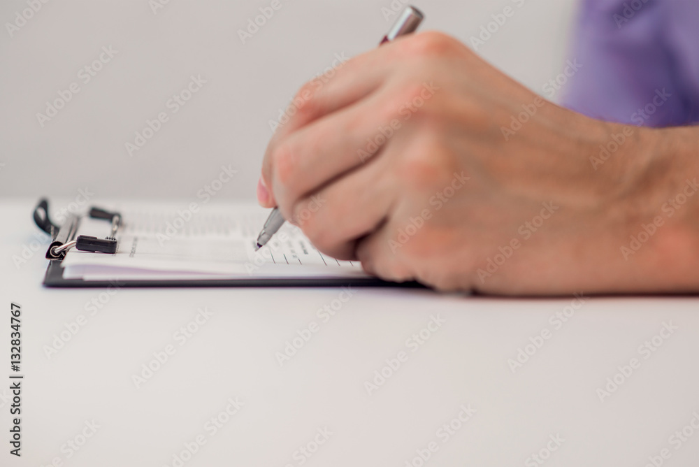 Fototapeta premium Close up of the hands of a businessman in a suit signing or writing