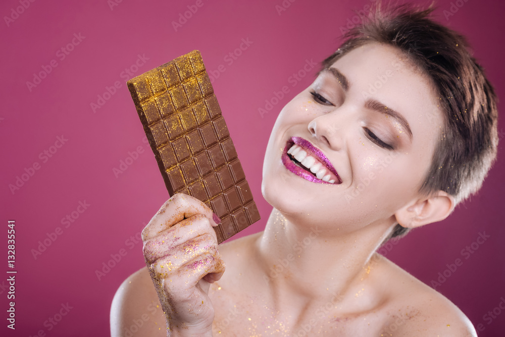 Joyful delighted model posing with chocolate bar Joyful delighted model posing with chocolate bar