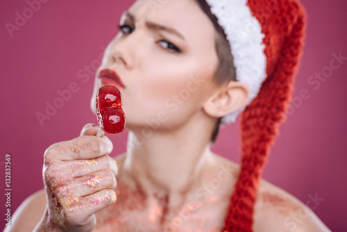 Attractive woman pointing at you wit lollipop