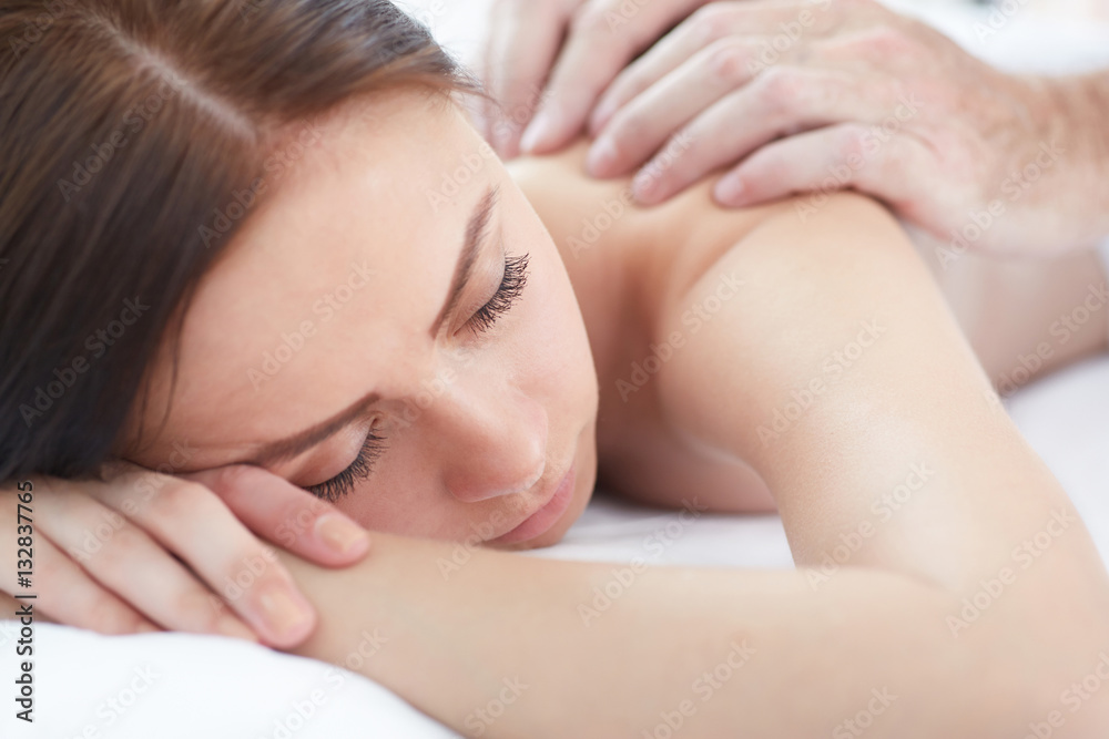 Woman enjoying a wellness back massage in a spa. Woman enjoying a wellness back massage in a spa.