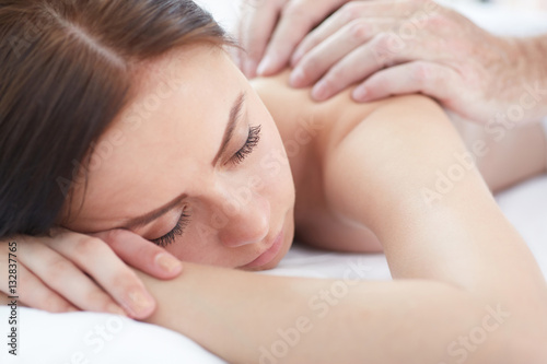 Woman enjoying a wellness back massage in a spa.