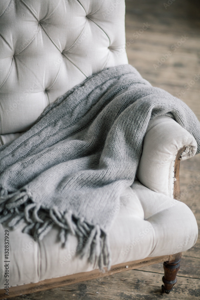 Still life details, wool grey plaid on retro vintage wooden sofa Still life details, wool grey plaid on retro vintage wooden sofa