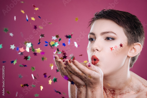 Nice beautiufl woman posign with tinsels on pink background photo