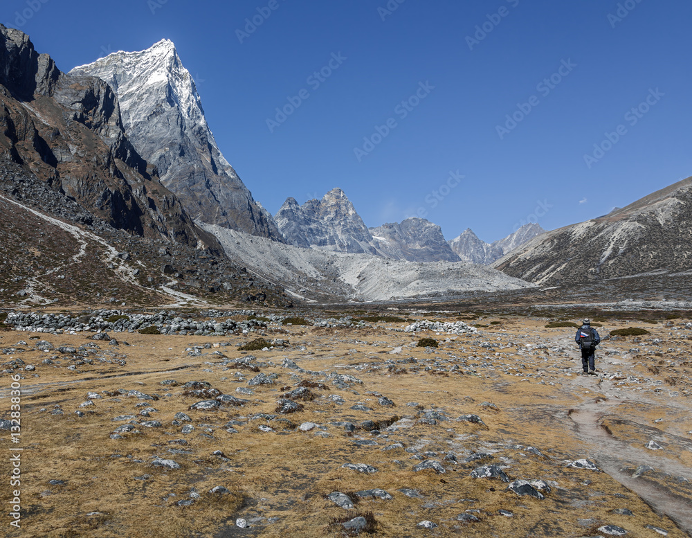 A tourist goes on a trail to Everest near Periche village - Everest region, Nepal, Himalayas