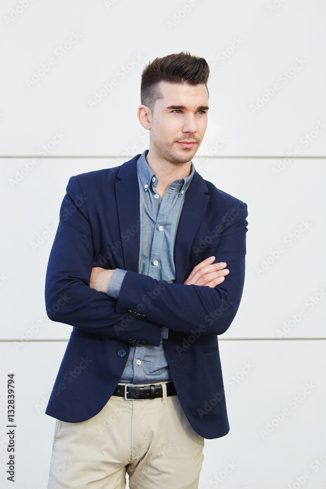serious young business man standing with arms crossed serious young business man standing with arms crossed