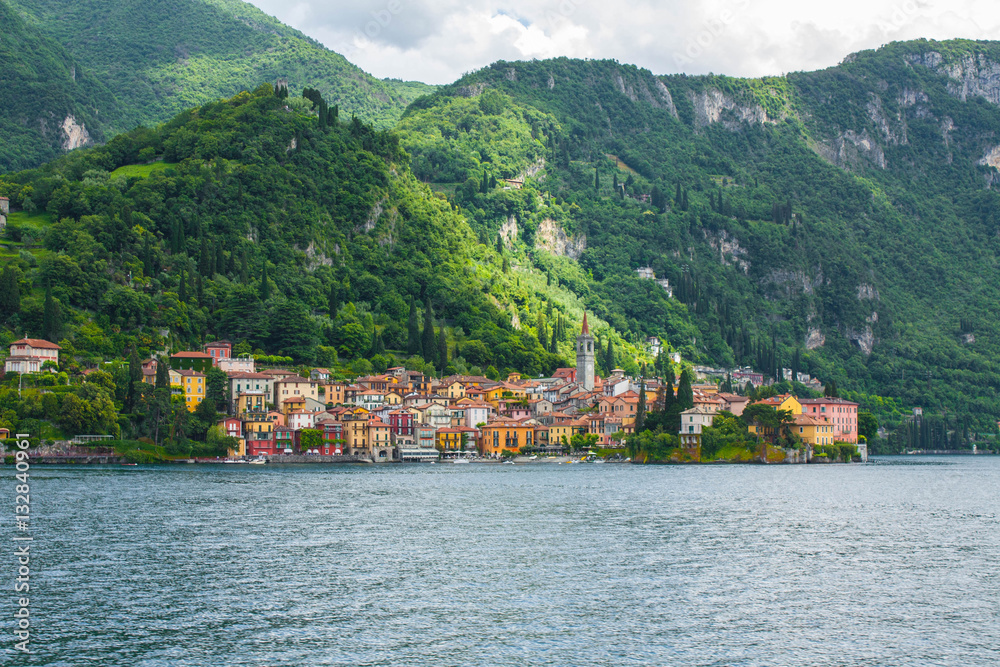 View on coast line of Lake Como, Italy, Lombardy region. Italian landscape, with Mountain and city with many colorful buildings on the shore