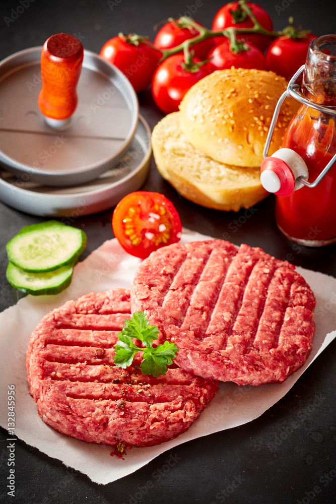 Uncooked raw hamburger patties with toppings Uncooked raw hamburger patties with toppings