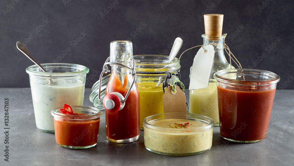 Front view on delicious condiments on gray surface
