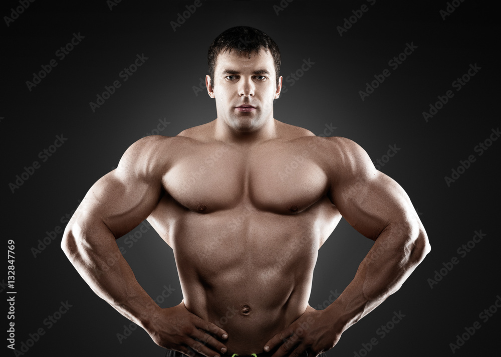 Handsome muscular bodybuilder posing over black background. Handsome muscular bodybuilder posing over black background.