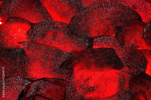 Food background. Thin beet slices glow from the inside.