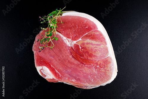 Raw gammon steak on black background with thyme Fototapeta