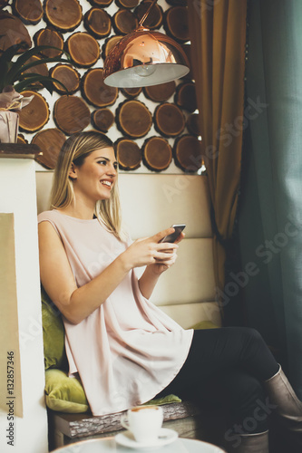 Woman sitting in cafe and u...