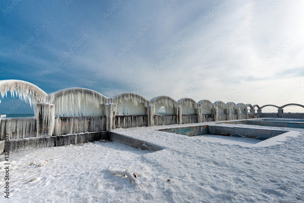 Icicles over the arches of the abandoned swimming pool by the sea
