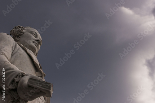 Statua di Carlo Goldoni su sfondo cielo grigio e nuvoloso, Firenze, Italia