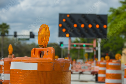 Road closed signs detour traffic temporary street work orange lighted arrow and barrels photo