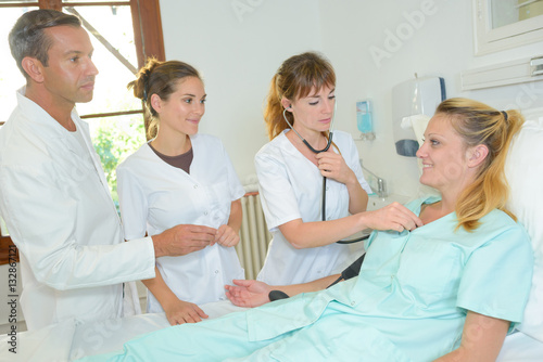 Slika na platnu Medical staff surrounding patient's bed