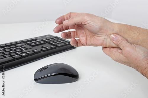 femme senior ayant mal au poignet en travaillant sur son ordinateur