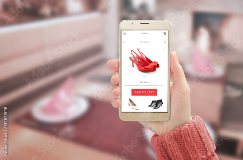 Woman showing modern gold smart phone with online shopping app on device display. Woman red shoes and add to cart button.