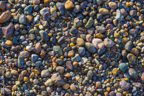 Beautiful colorful pebble stones on beach California background pattern texture