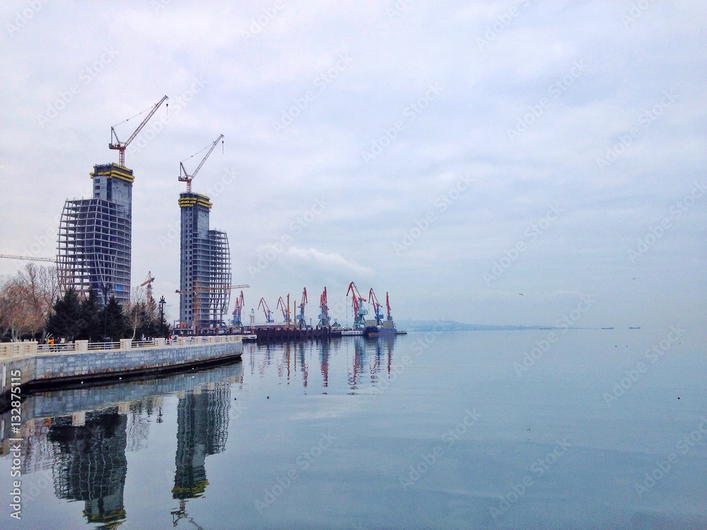 Fototapeta premium Embankment with construction site and cranes at a port