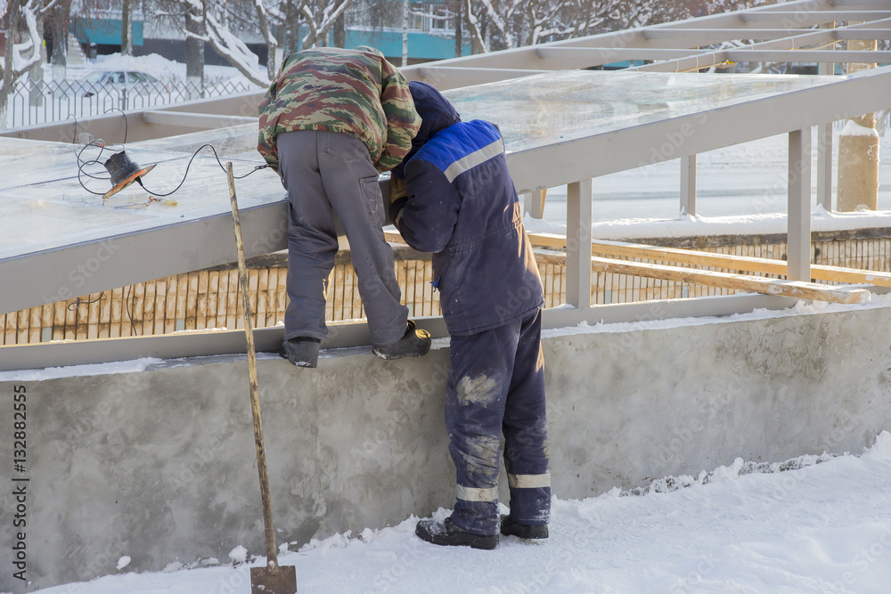 Two workers glaze the roof of the underpass Two workers glaze the roof of the underpass