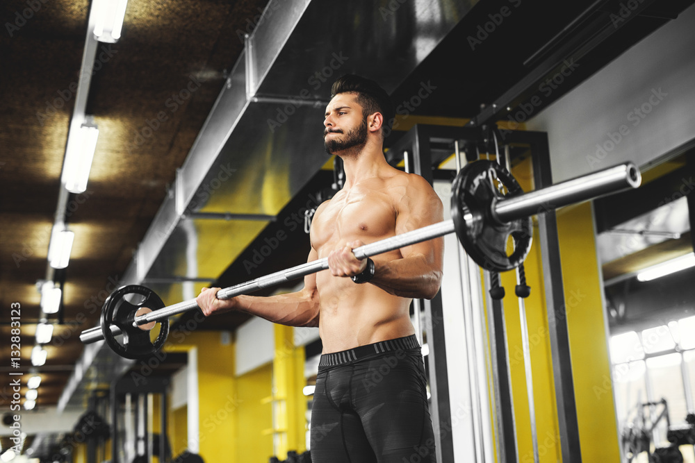 Muscular bodybuilder lifting weights at the gym.
Muscular bodybuilder lifting weights at the gym.