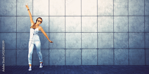 young attractive girl listening music with headphone and shows t