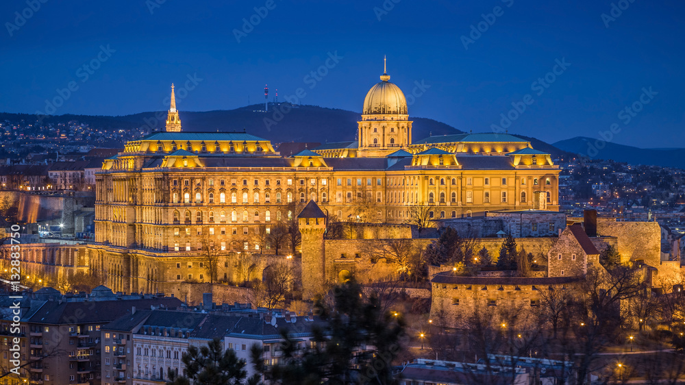 Fototapeta premium Budapest, Hungary - The beautiful Buda Castle (Royal Palace) as seen from Gellert Hill illuminated in winter time at blue hour