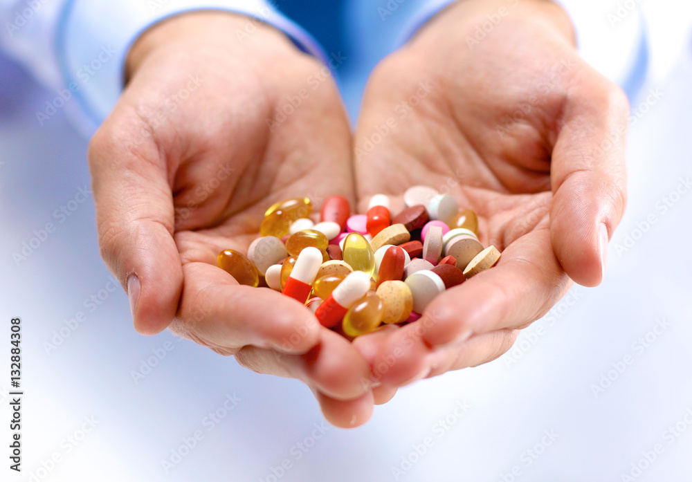 Fototapeta premium young doctor holds the patient's hand with pills