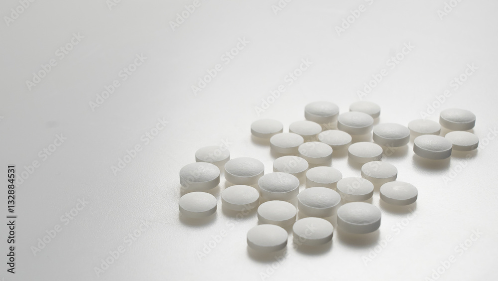white round pills neatly stacked on a white background white round pills neatly stacked on a white background