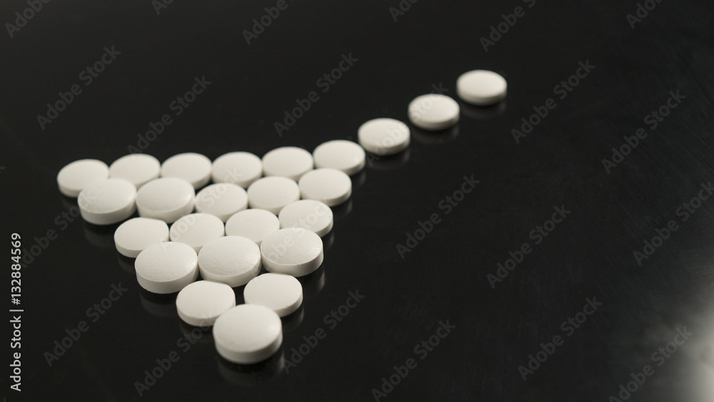 white round pills are laid out on a black background white round pills are laid out on a black background