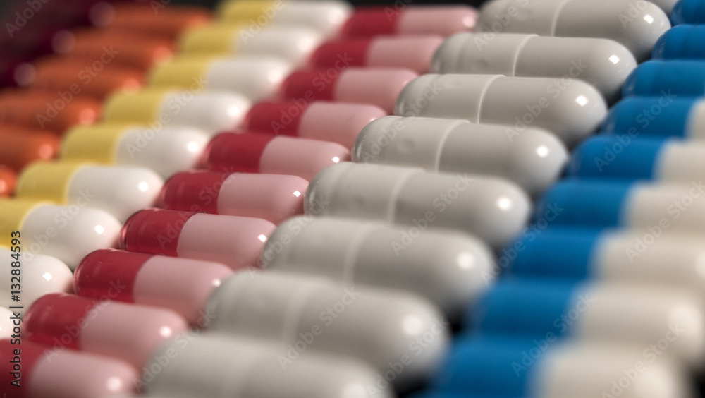 multicolored capsules neatly stacked in a row multicolored capsules neatly stacked in a row