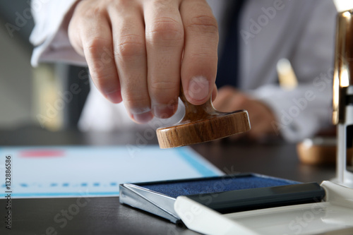 Notary public hand with wooden stamp