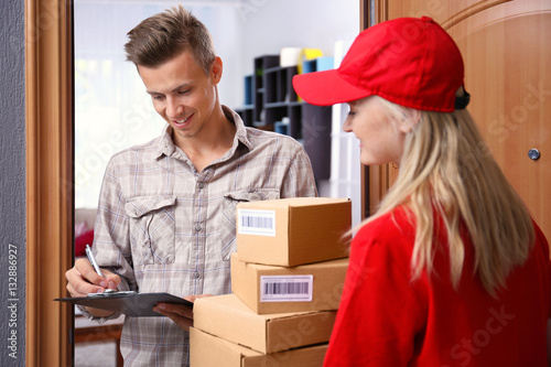 Bilde på lerret Young man receiving package from courier