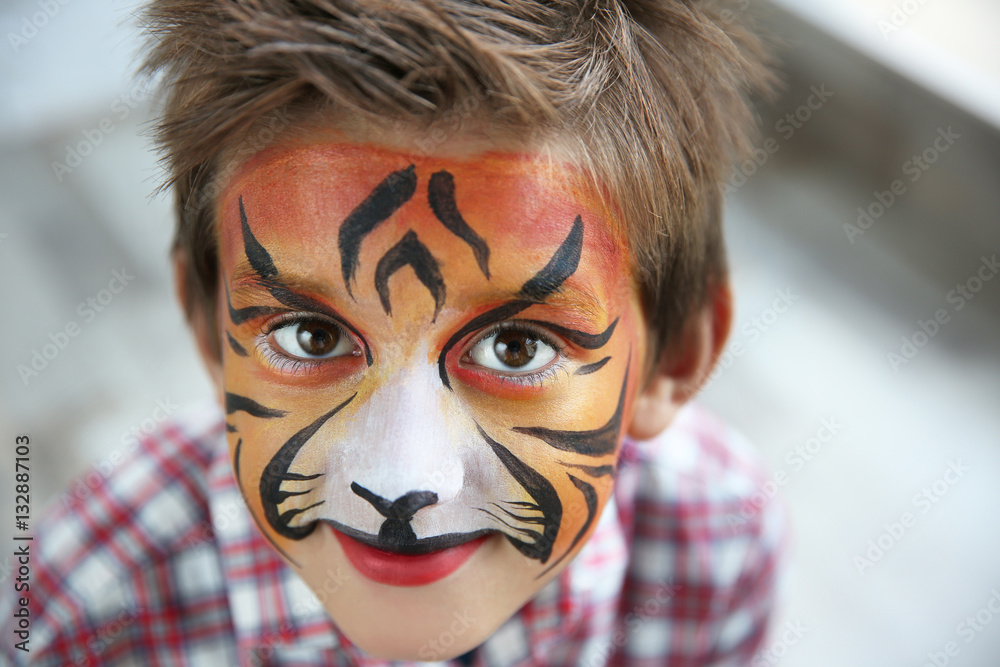 Obraz premium Cute little boy with aqua makeup of tiger muzzle