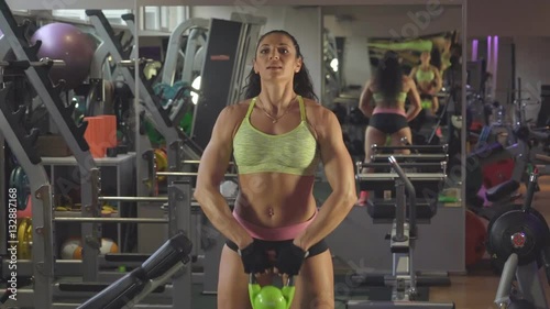 Exercise with weights. Lifting weights to his chest