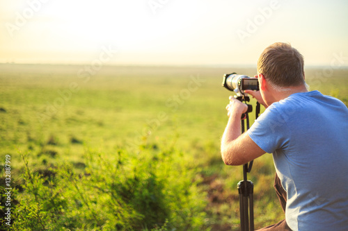 Professional photographer taking photo on savannah