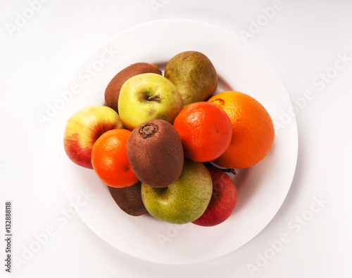 Still life lot of different fruits on the plate kiwi Mandarin pe