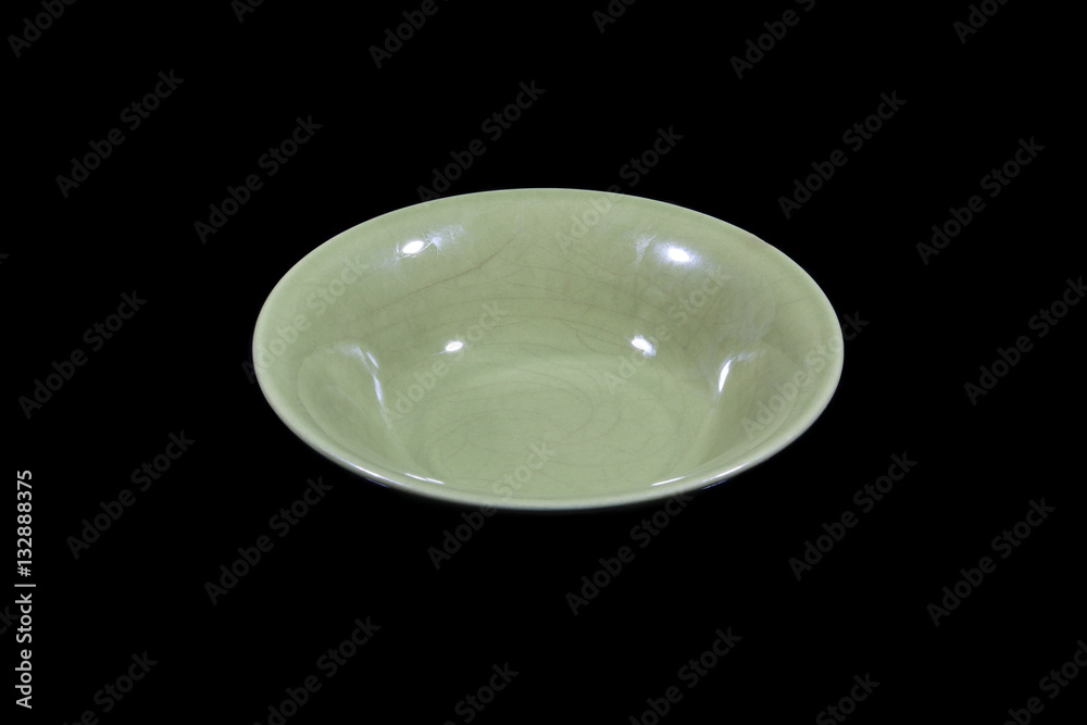 Soup deep green plate with round shoulders on wooden cutting board from side Soup deep green plate with round shoulders on wooden cutting board from side