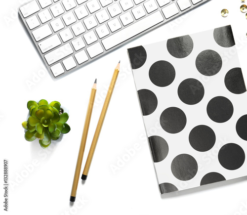 Flat lay of golden stationery with keyboard on white background