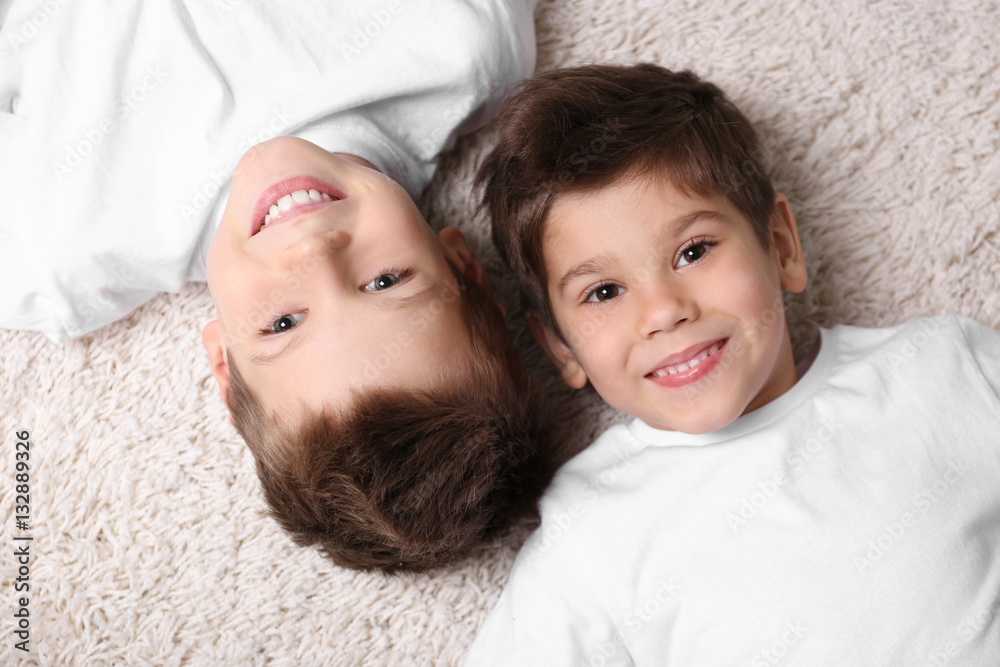 Cute little brothers lying on carpet at home Cute little brothers lying on carpet at home