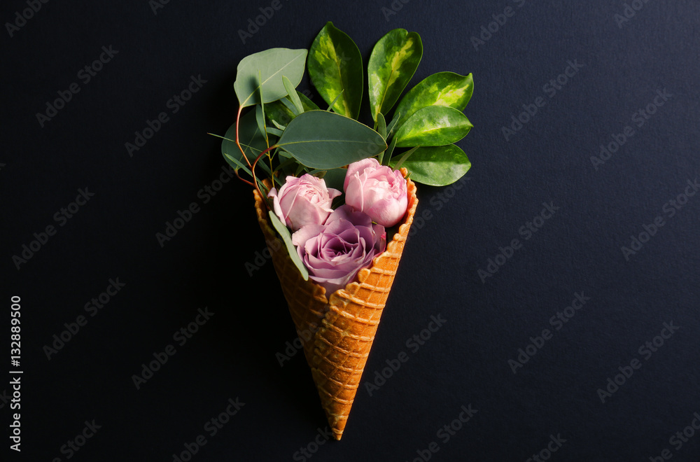 Waffle cone with composition of roses and branches on dark background Waffle cone with composition of roses and branches on dark background