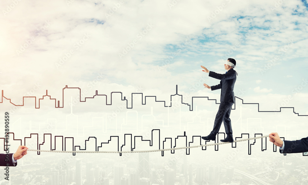 Business concept of risk support and assistance with man balancing on rope Business concept of risk support and assistance with man balancing on rope