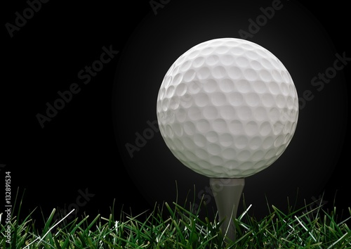 Golf ball  with tee in the grass on black background