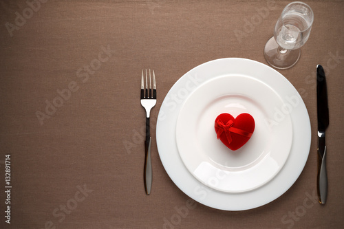 Table set with red heart on the white plate for Valentines day.