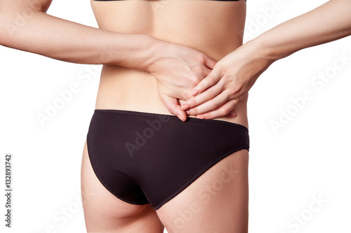 Closeup view of a young woman with pain in kidneys. isolated on white background.   © khosrork