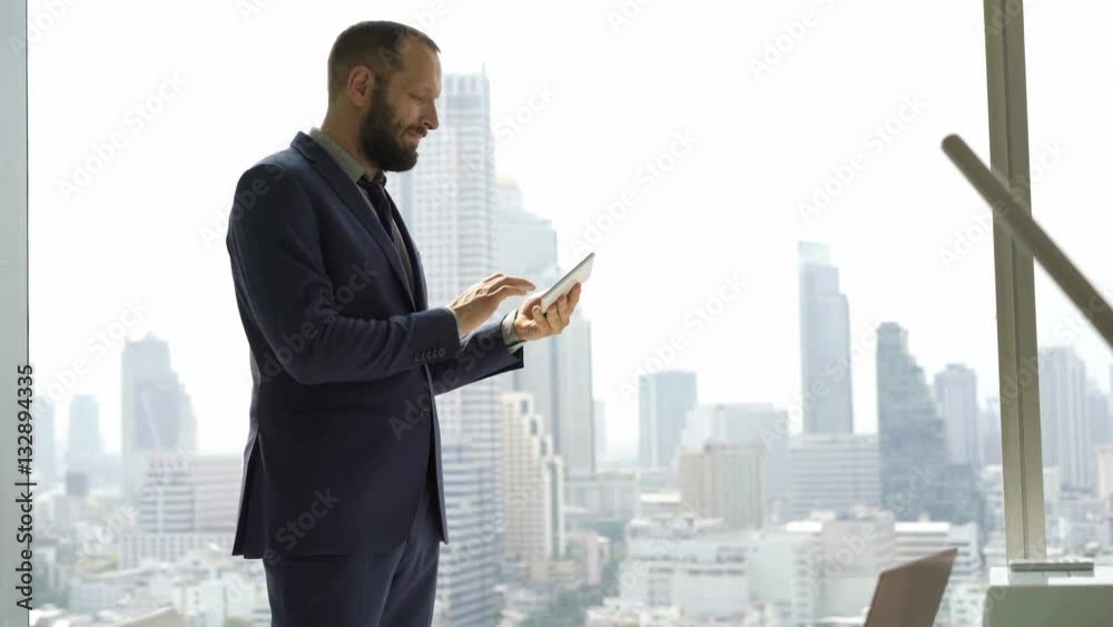 Young businessman using tablet computer standing by window in office
Young businessman using tablet computer standing by window in office