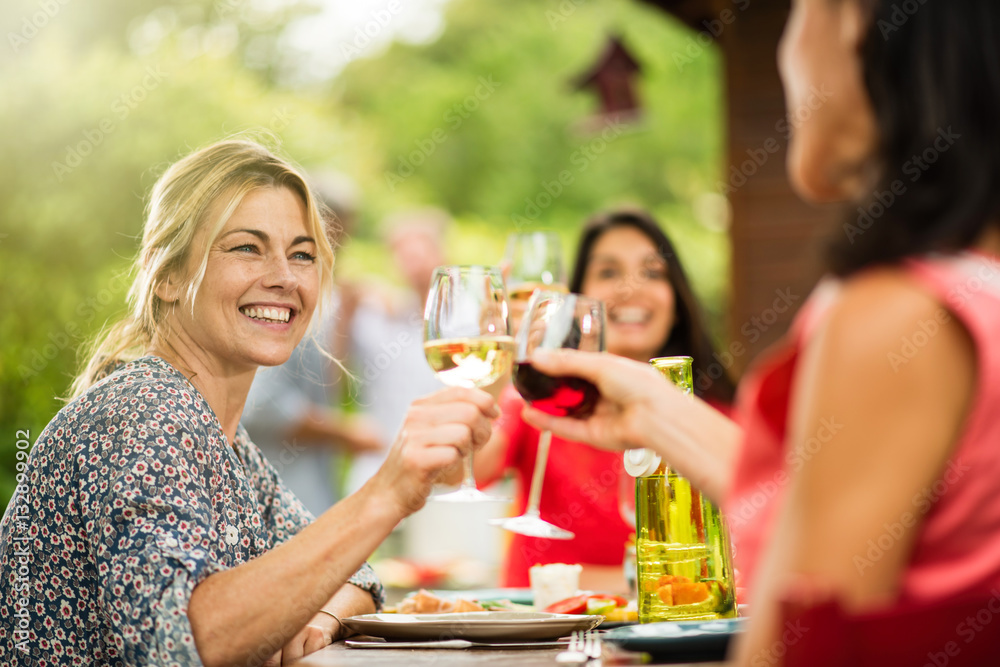 Group of friends having lunch, focus on a woman Group of friends having lunch, focus on a woman