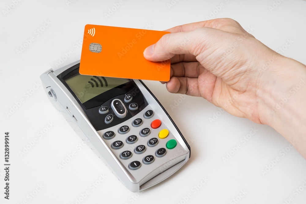 Customer is paying using contactless credit card and payment terminal. Customer is paying using contactless credit card and payment terminal.